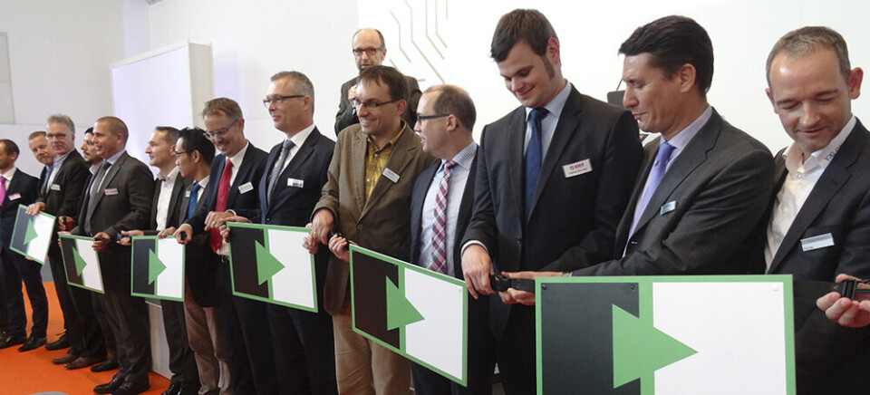Medlemmer i Hermes-alliansen med ny logo som i fremtiden skal vise at maskiner er Hermes-kompatible. Det skal være mulig å «ettermontere» kompatibilitet i eksisterende utstyr. Foto: Rolf Sylvester-Hvid, Aktuel Elektronik.