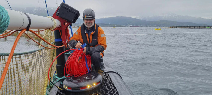 Her er Kjell Mikalsen i ferd med å montere en av prototypene ute på et anlegg i sjøen.