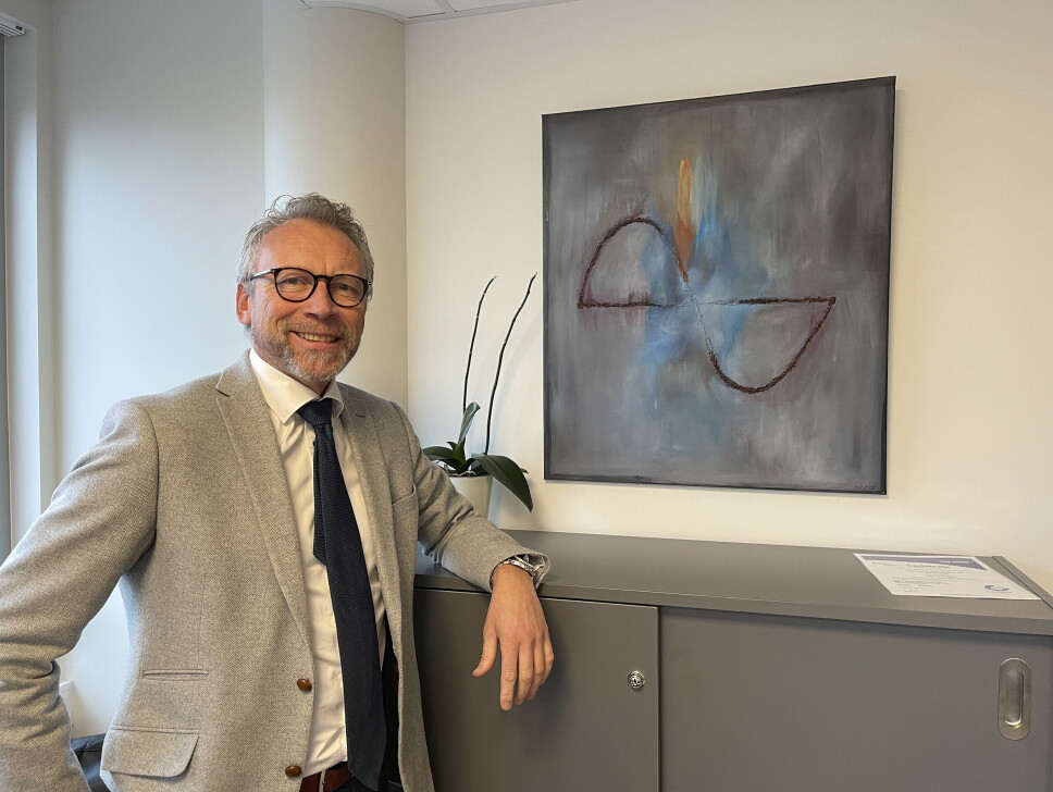 Administrerende direktør Lasse Olav Irvam i Optronics Technology ved en kunstnerisk versjon av logoen, utført av ektefellen til en av de ansatte.