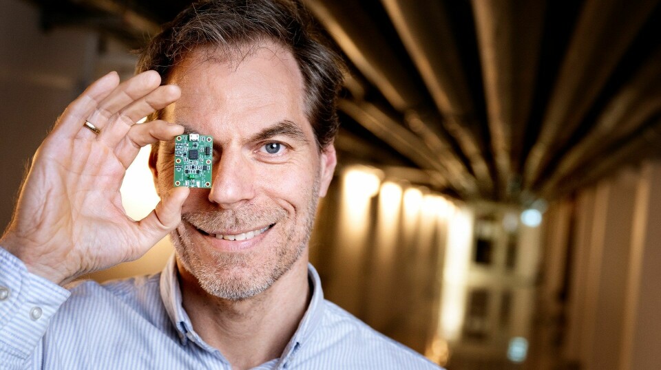 Professor Ulrik Lund Andersen fra DTU viser den nyeste versjonen av en kvantemekanisk tilfeldighetsgenerator, som skal ned i brikkestørrelse for å kunne bli inkludert i elektronikken til mobiltelefoner. Foto: Bax Lindhardt