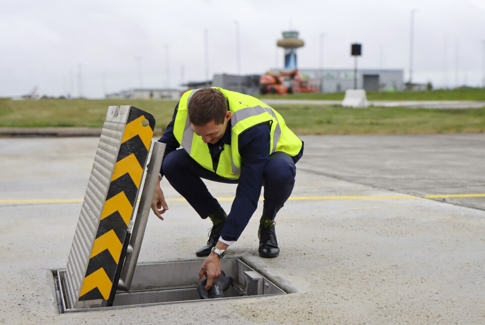 Klima- og miljøminister Andreas Bjelland Eriksen ved den nye elflyladeren på Stavanger lufthavn.