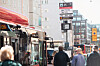 Passasjerer venter ved en travel bussholdeplass med digitale informasjonsskilt.